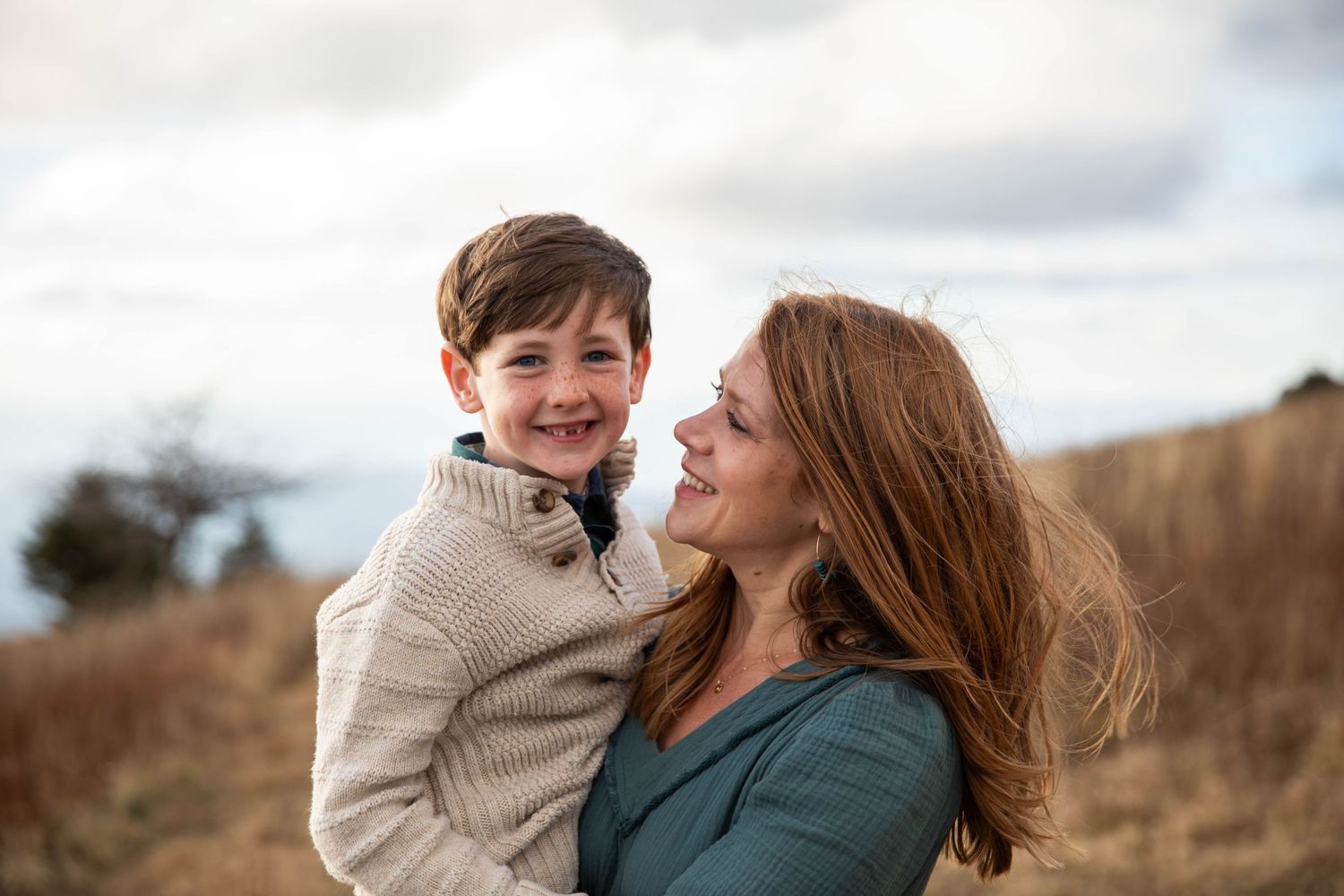 Photo of a mother holding her son on Whitetop Mountain in southwest Virginia during a family photo shoot at sunset