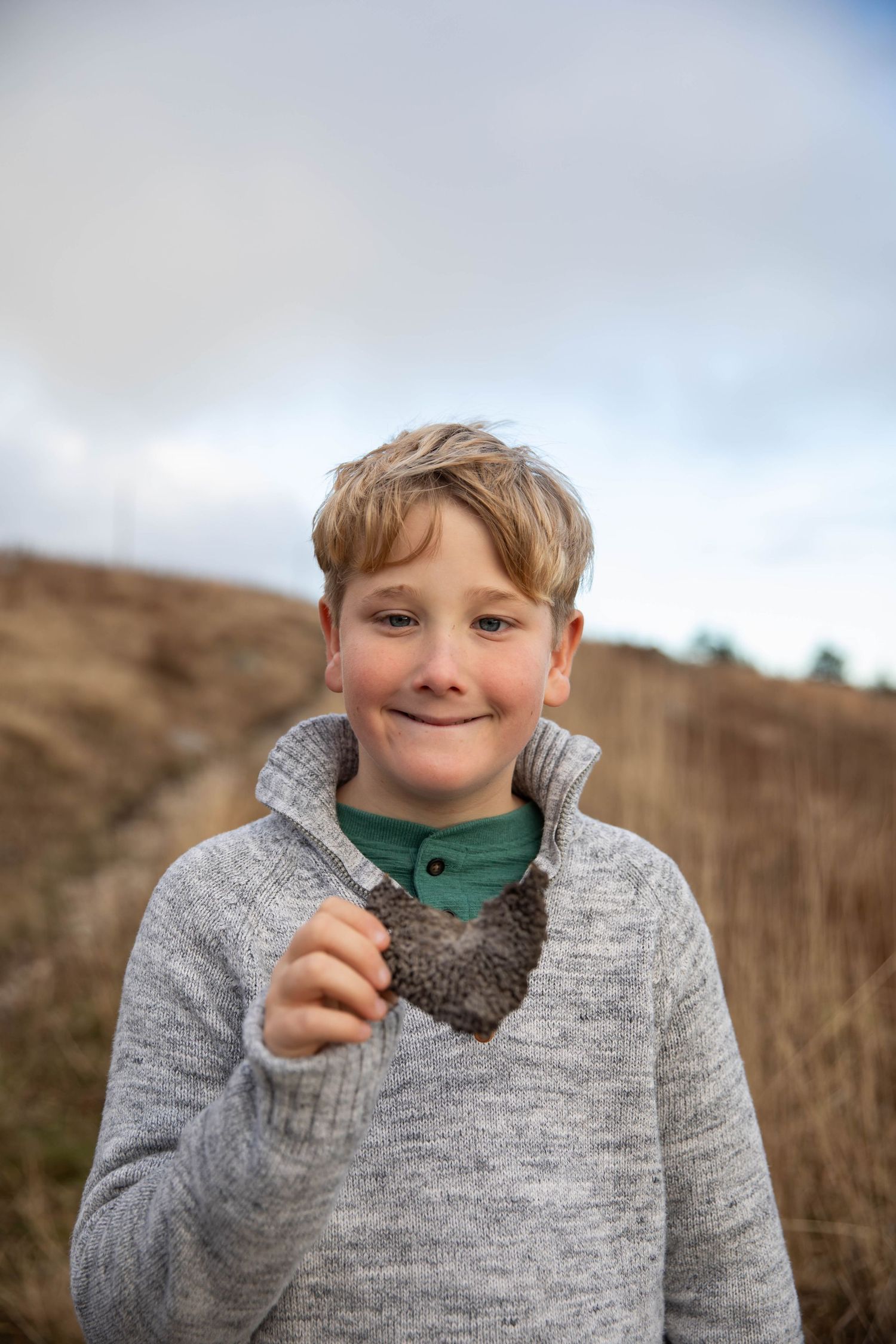 Photo of a boy on a mountain, smiling at the camera during a family photo shoot on Whitetop Mountain, Virginia