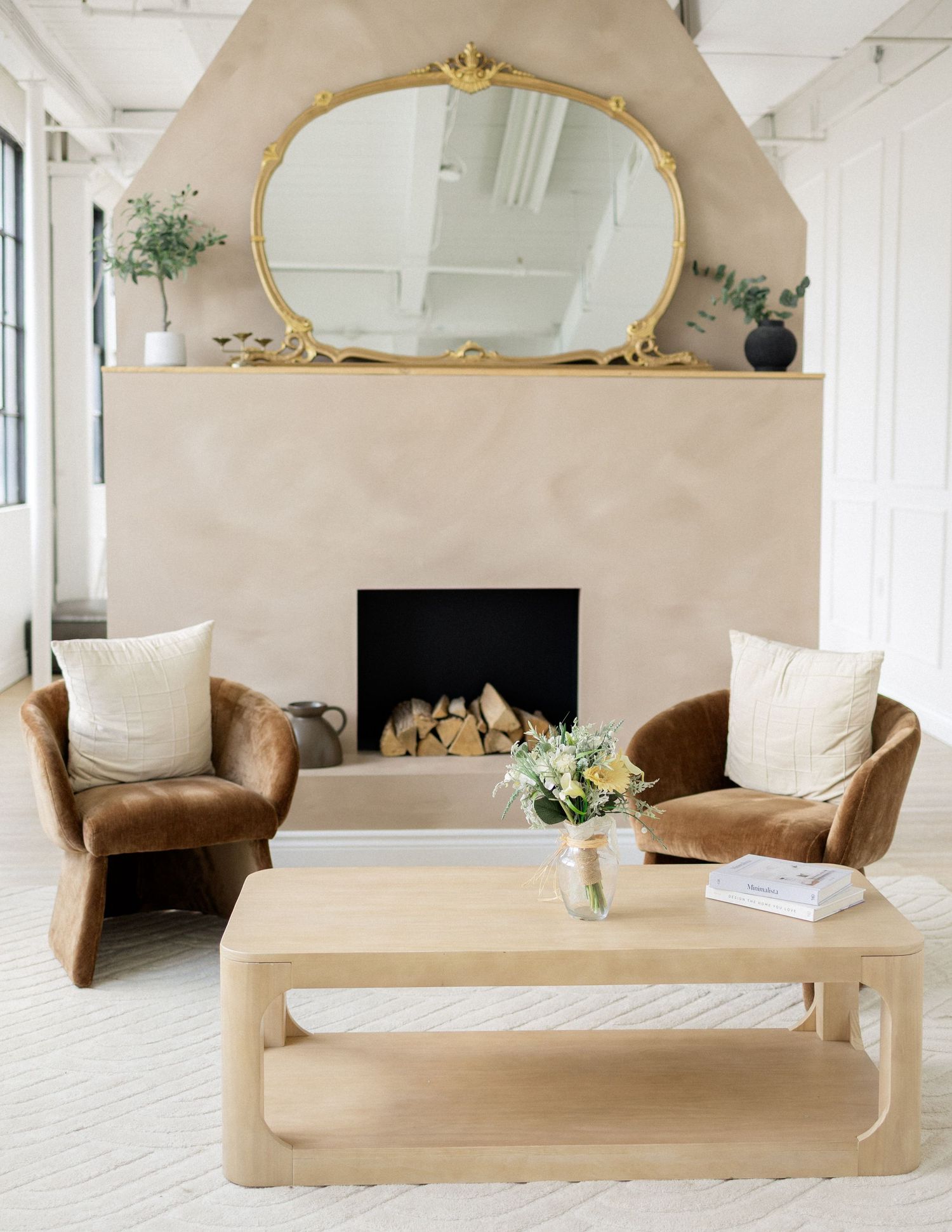 Styled branding photo of a modern living room interior with mirror, fireplace, and fresh florals at Parkhill Studios in Cambridge.