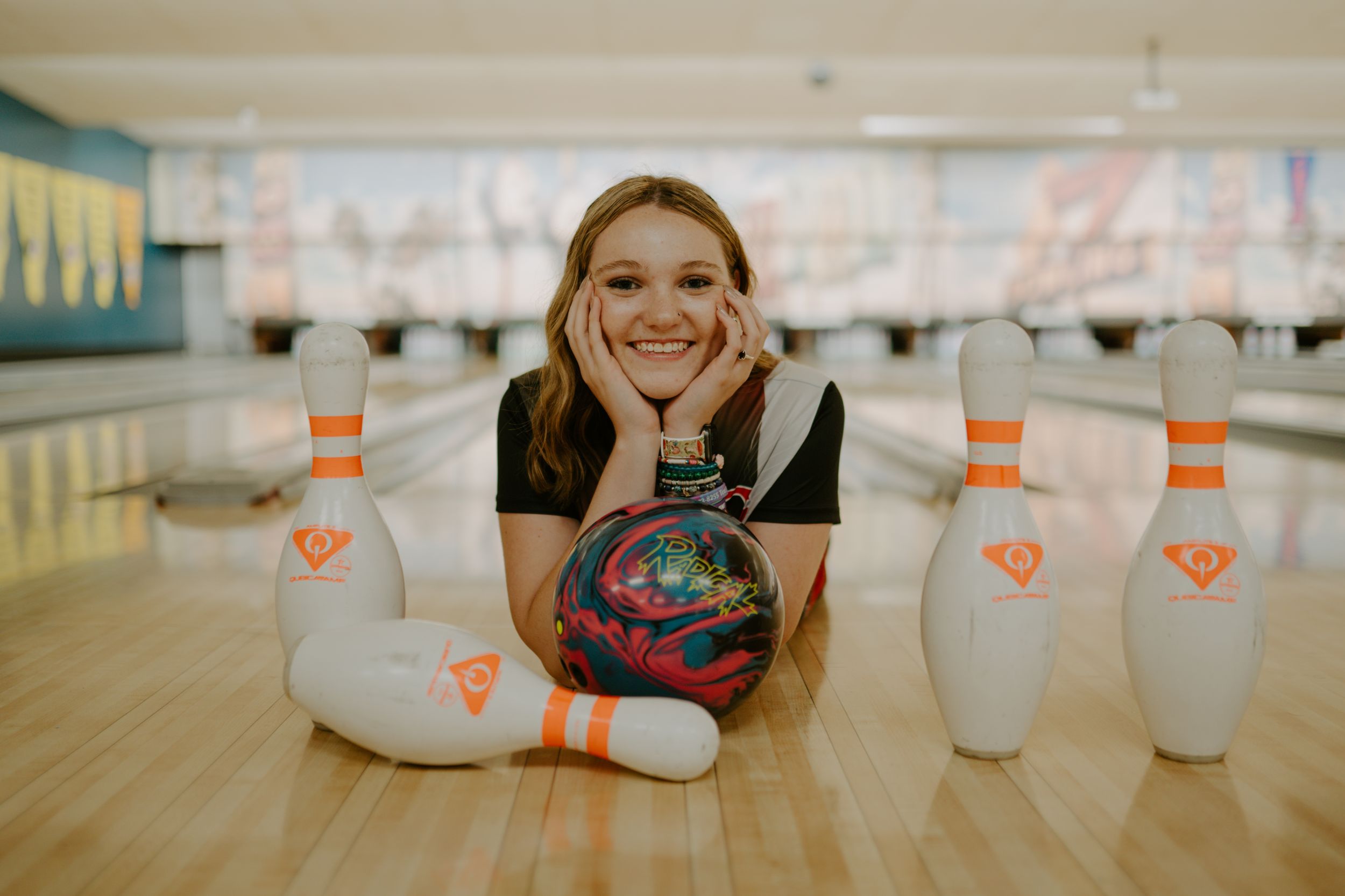 Fun candid moments captured at bowling alley with vintage-toned lighting.