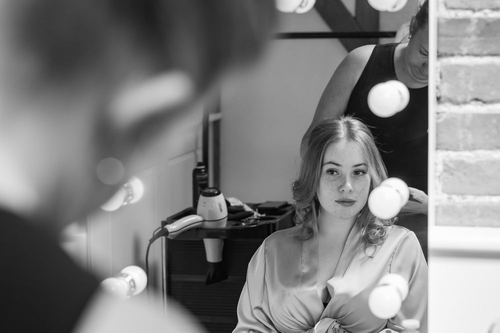 Black and white image of wedding preparation with soft lighting and bokeh effects.