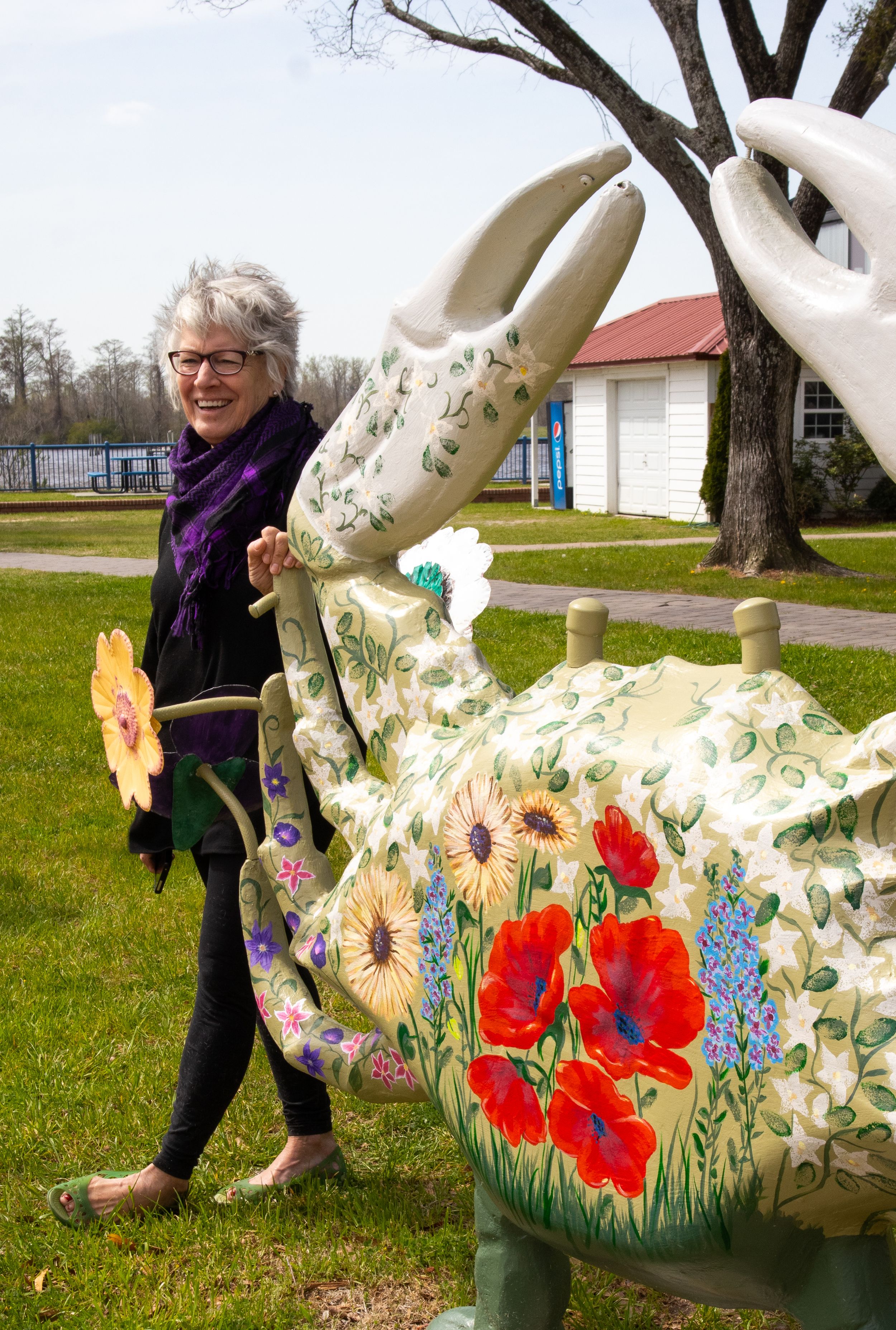 Artist Yvonne Curtis standing with her restoration of  “Rhapsody in Blue” with its new vibrant colors now known as  “Beauty is Everywhere”