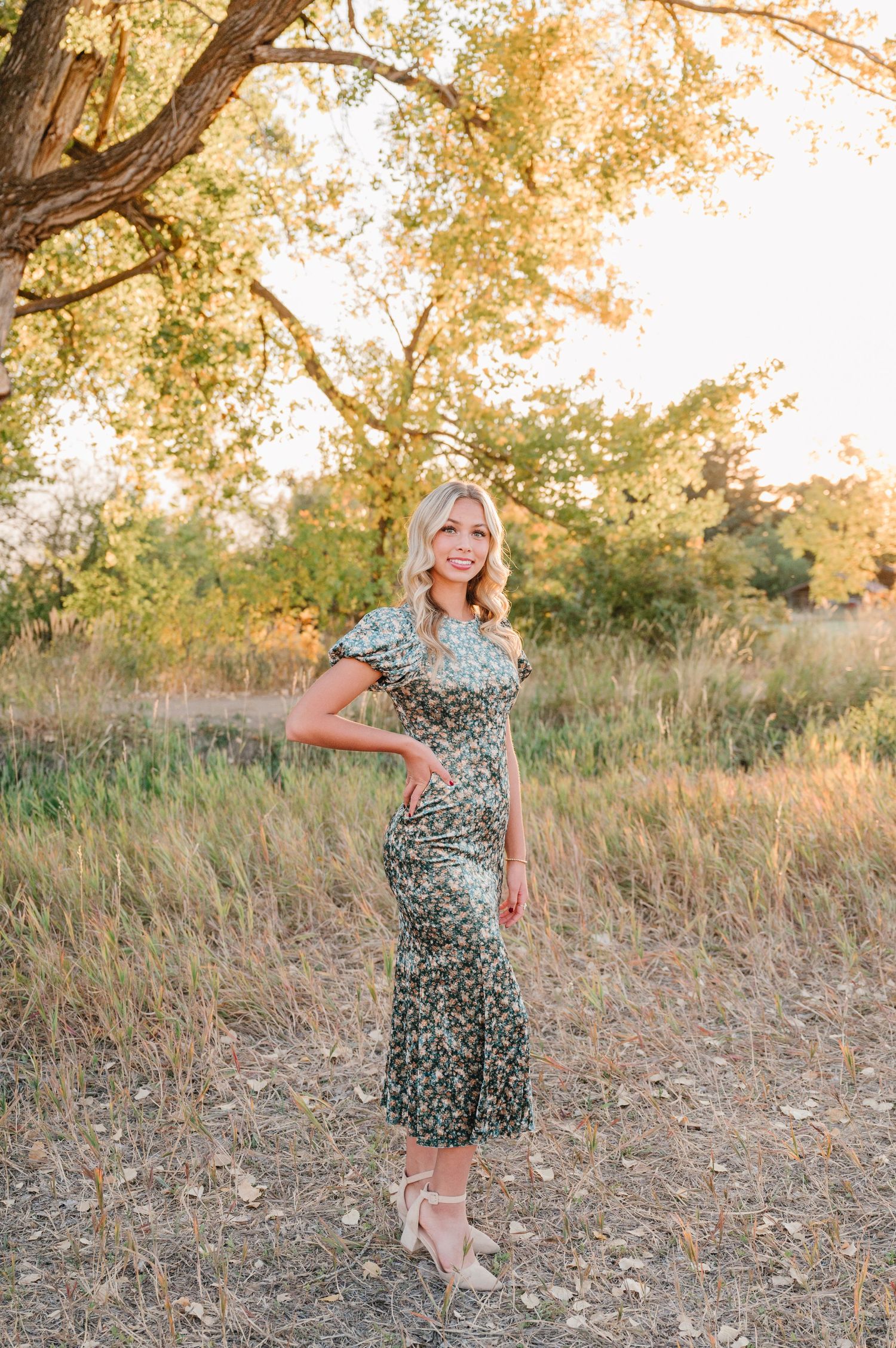 Outdoor portrait session featuring floral midi dress against autumn trees.
