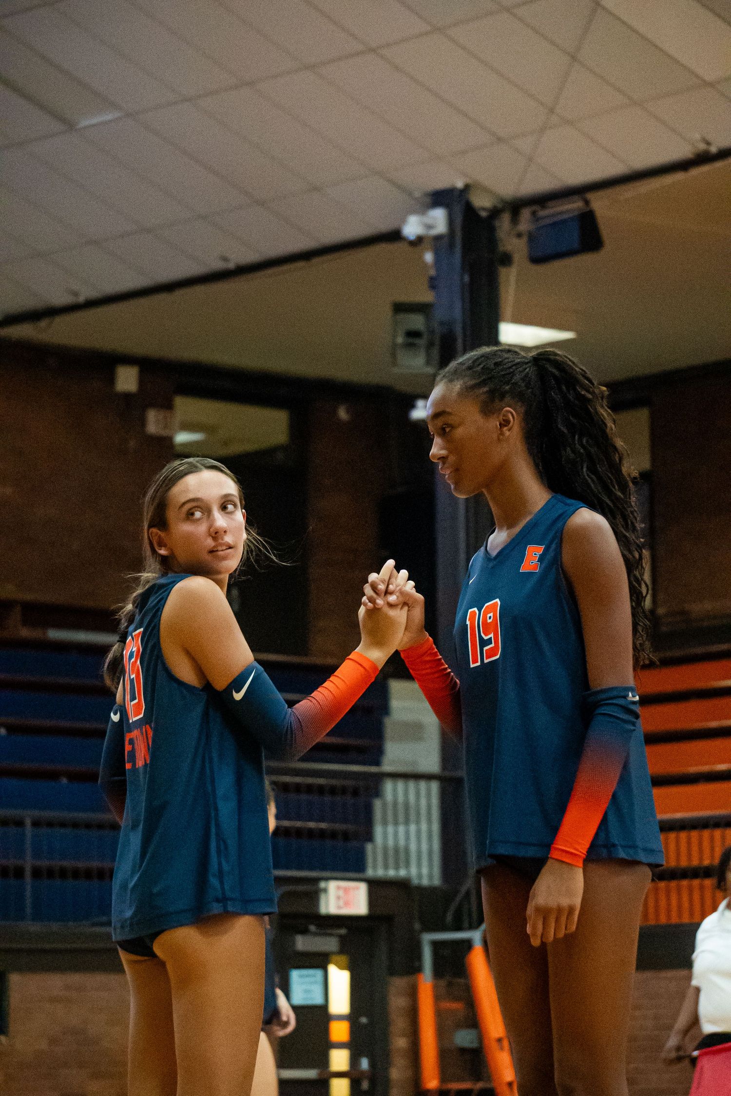 Teammates sharing celebratory high-five on basketball court.