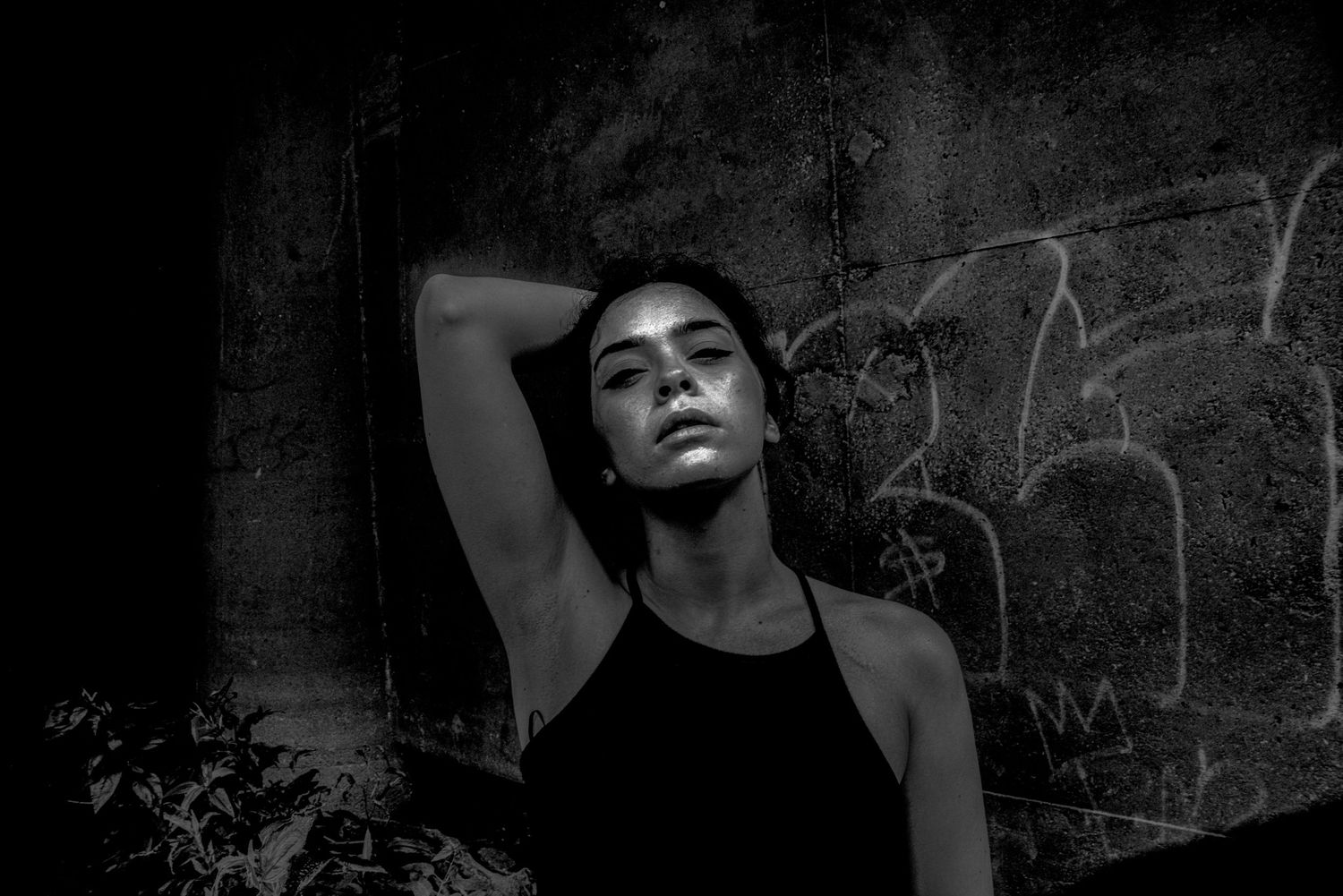 Dramatic black and white portrait with artistic lighting and urban backdrop.