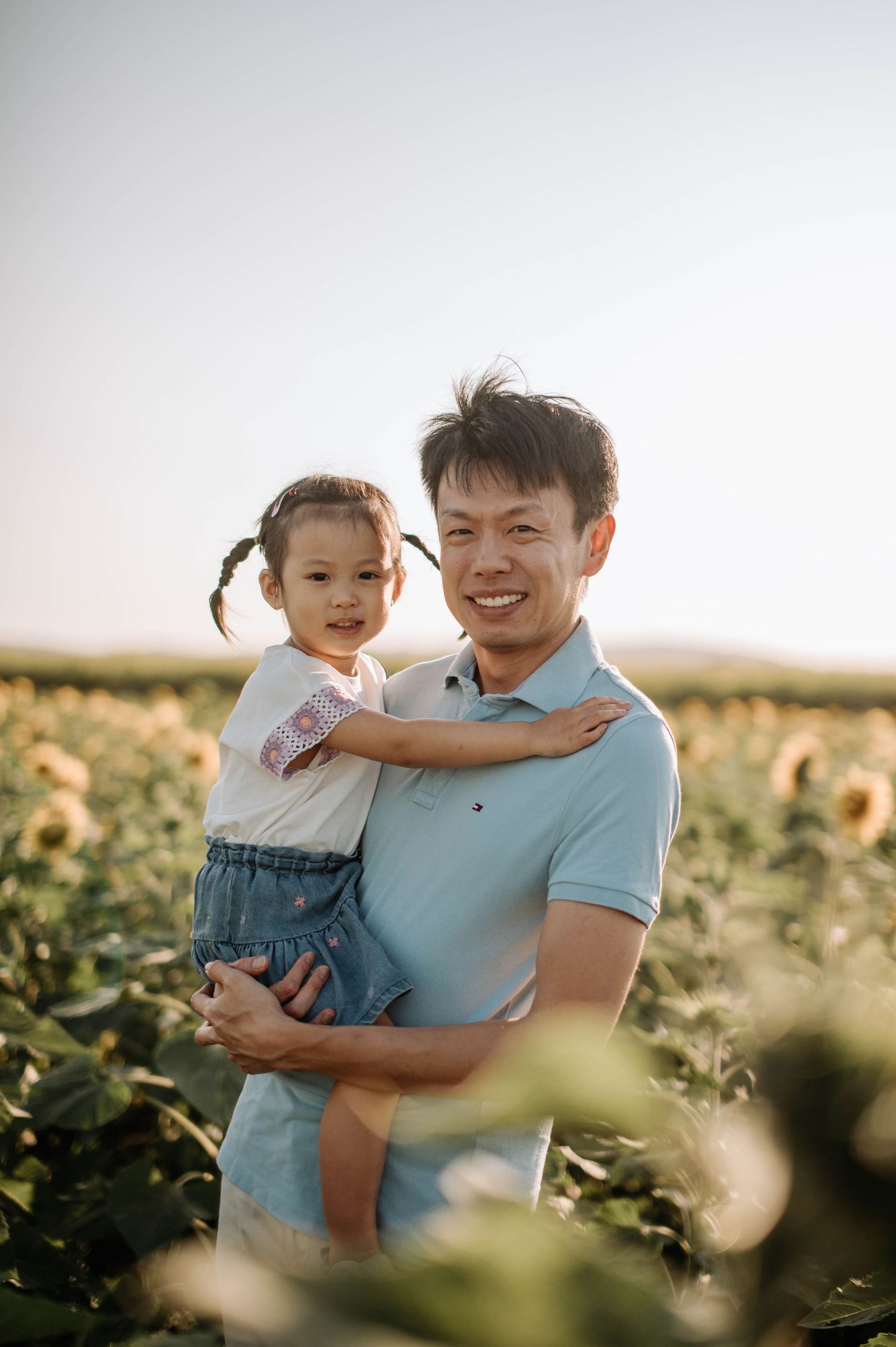 Sweet moment shared in a field of sunflowers during golden hour.