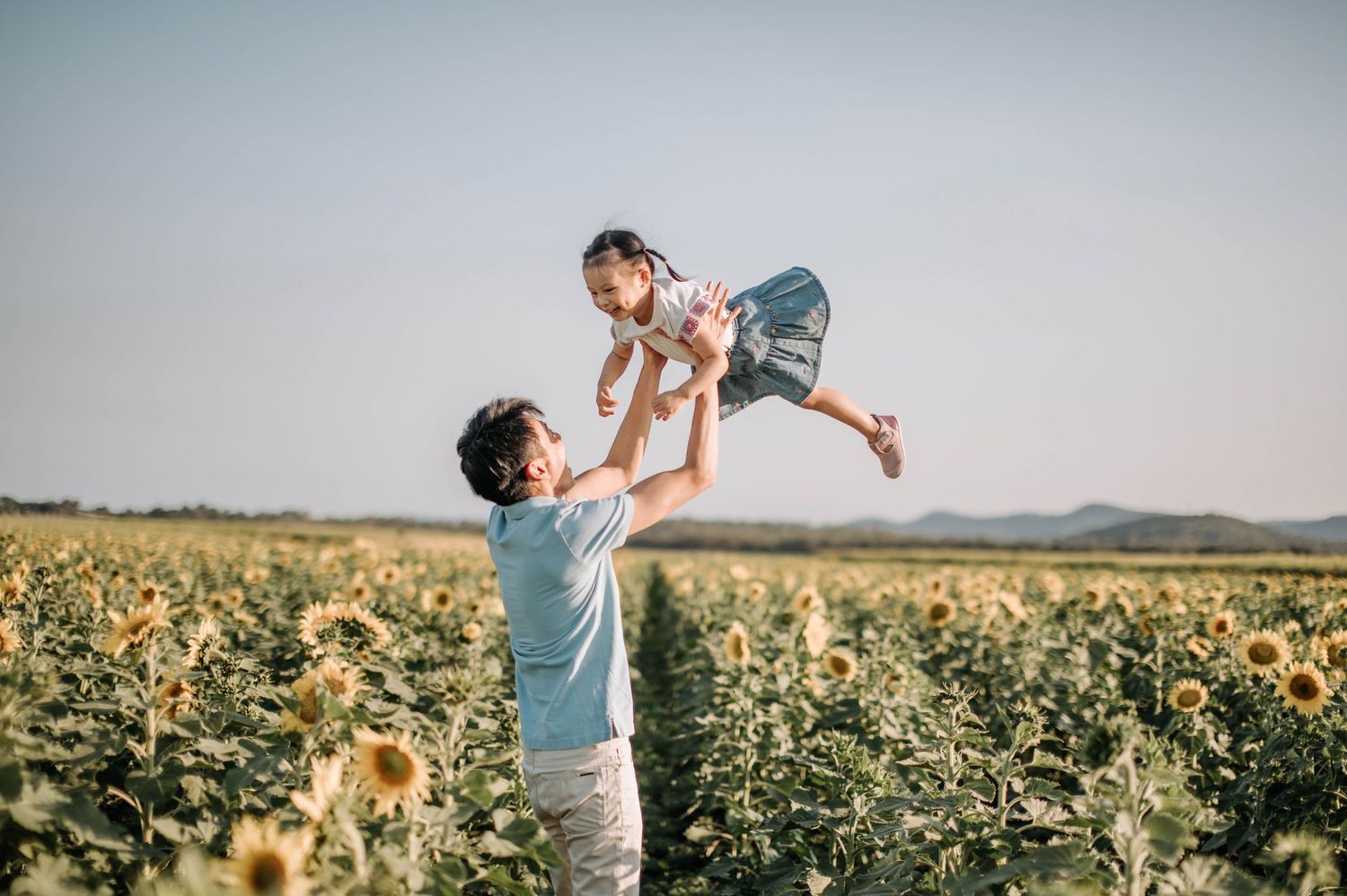 Loving moment captured while playing in a sunflower field.