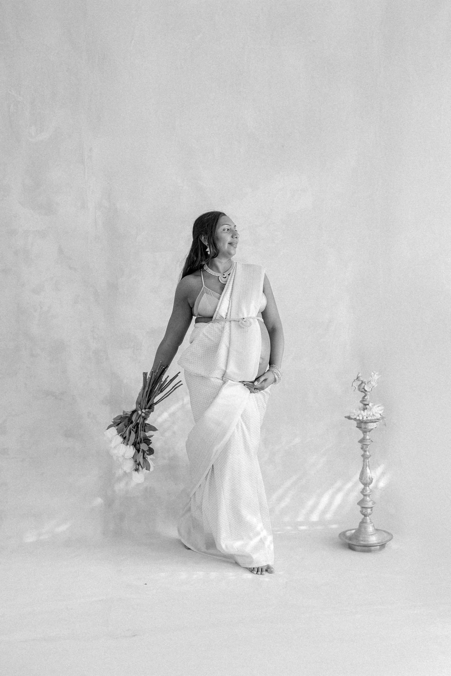 A figure in a flowing white dress performs an expressive dance sequence against a light gray backdrop.