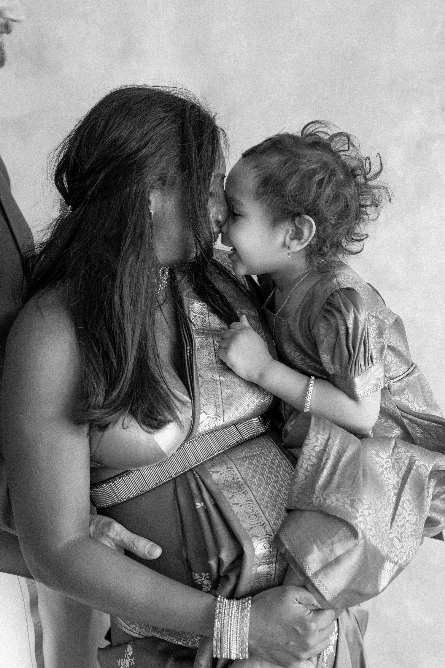 A series of five connected images showing a tender family moment with a parent holding a child in a red dress.