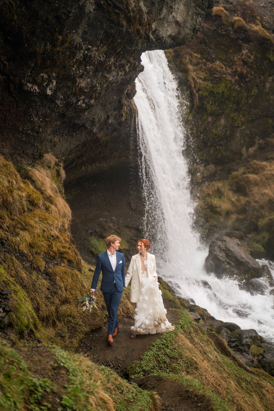 Elopement couple standing near Selvallafoss waterfall on the Snæfellsnes Peninsula in Iceland