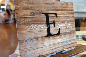 Rustic wooden wedding guest book sign for Matthew and Lindsay, featuring monogram E and date June 13, 2023.