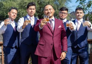 A group of formally dressed people raise glasses in a celebratory toast outdoors.