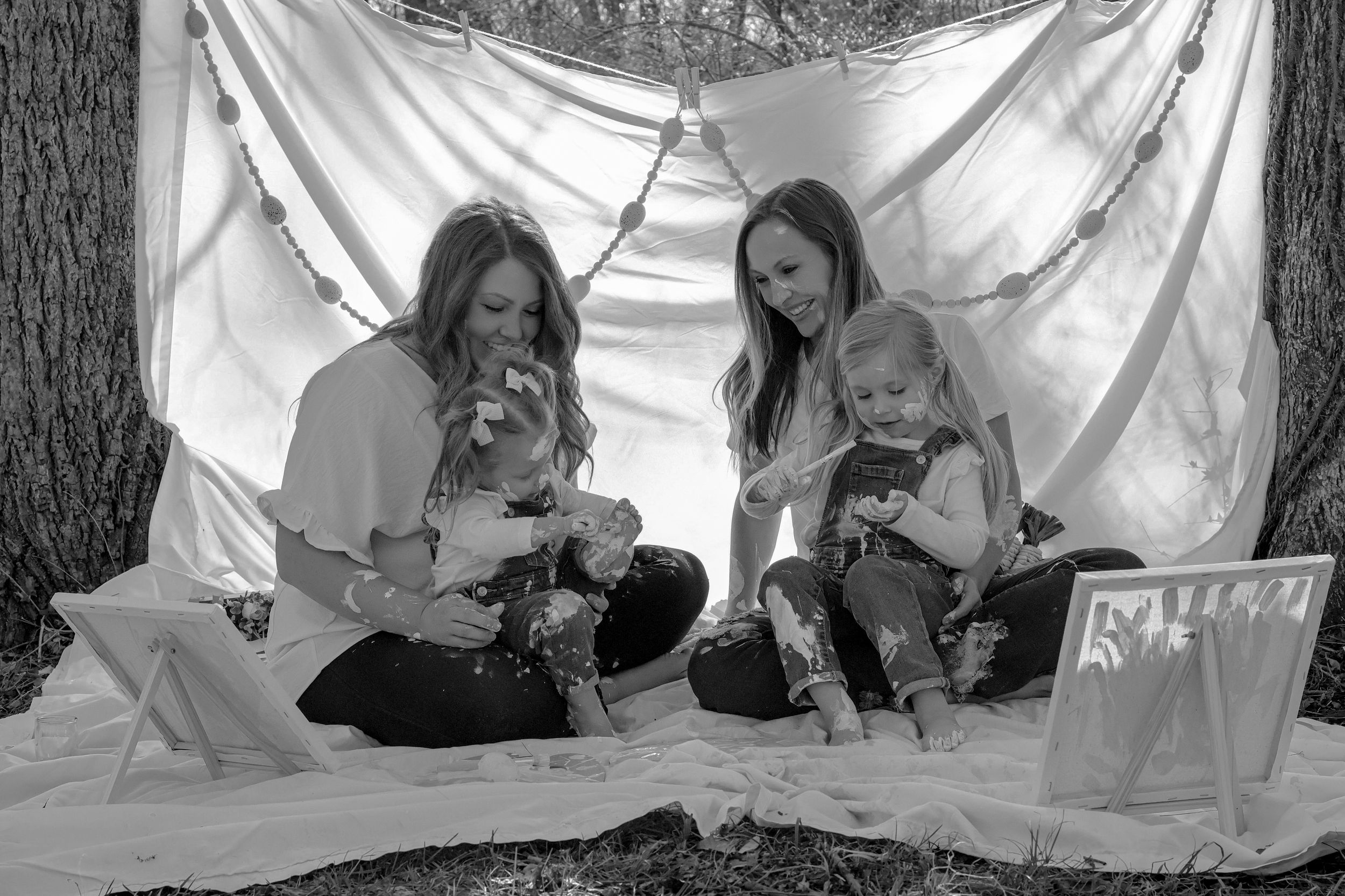 Black and white series of children playing beneath draped white fabric and paint.