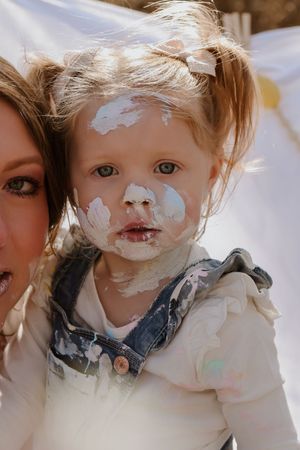 Paint-splattered faces and denim overalls during artistic playtime.