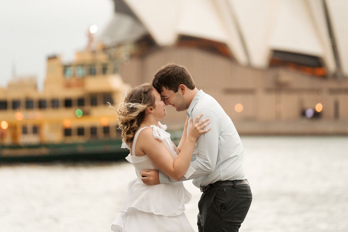 A romantic couple shares an intimate moment while hugging in front of the opera house at The Rocks in Sydney Photoshoot