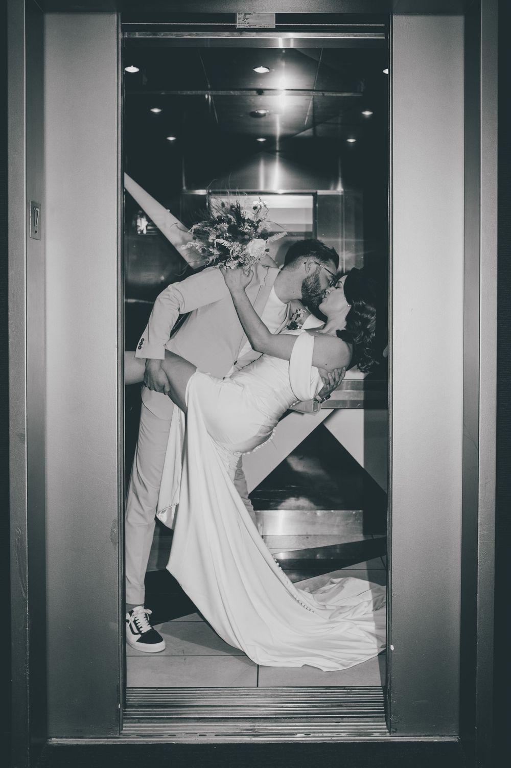 A black and white photo series shows a person in white clothing performing dramatic dance movements in a window display.
