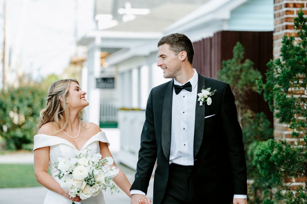 Bride and groom share romantic moments in a garden setting during their elegant outdoor wedding celebration.