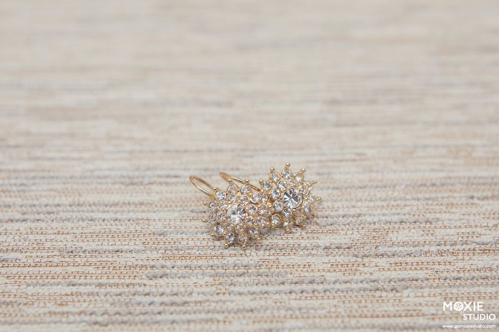 Small dried plant fragments scattered on a textured beige surface showing a progression from whole to broken pieces.