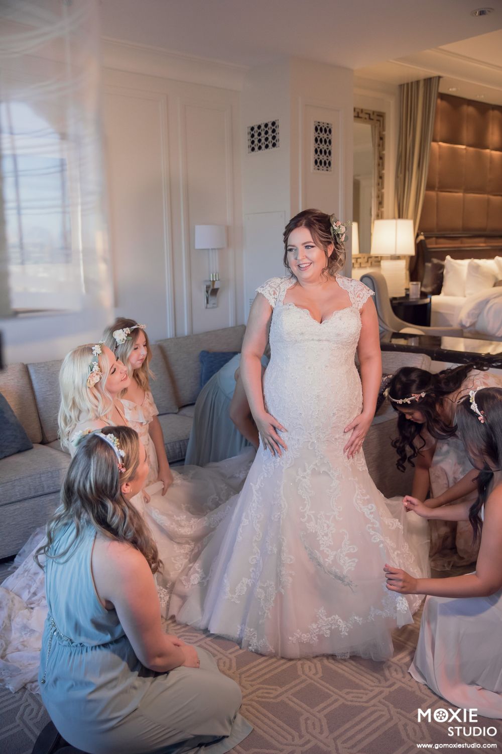 Wedding dress preparation scene showing final adjustments and fittings in an elegant hotel room.
