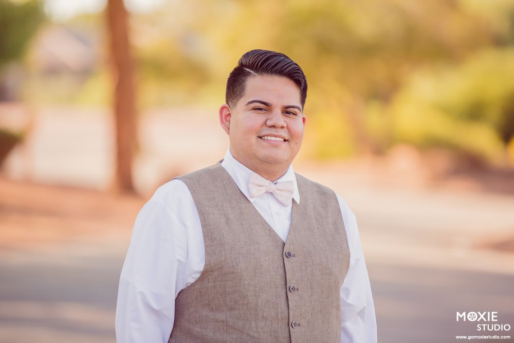 Wedding couple poses outdoors in a desert garden setting during golden hour with warm sunset lighting.