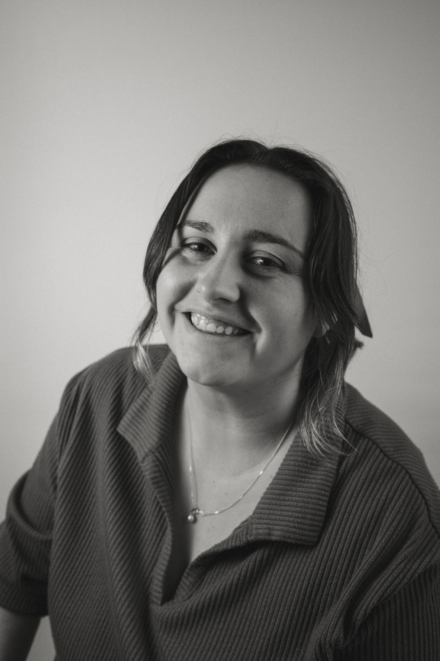 A series of black and white portraits showing someone in a dark sweater expressing different emotions and angles.