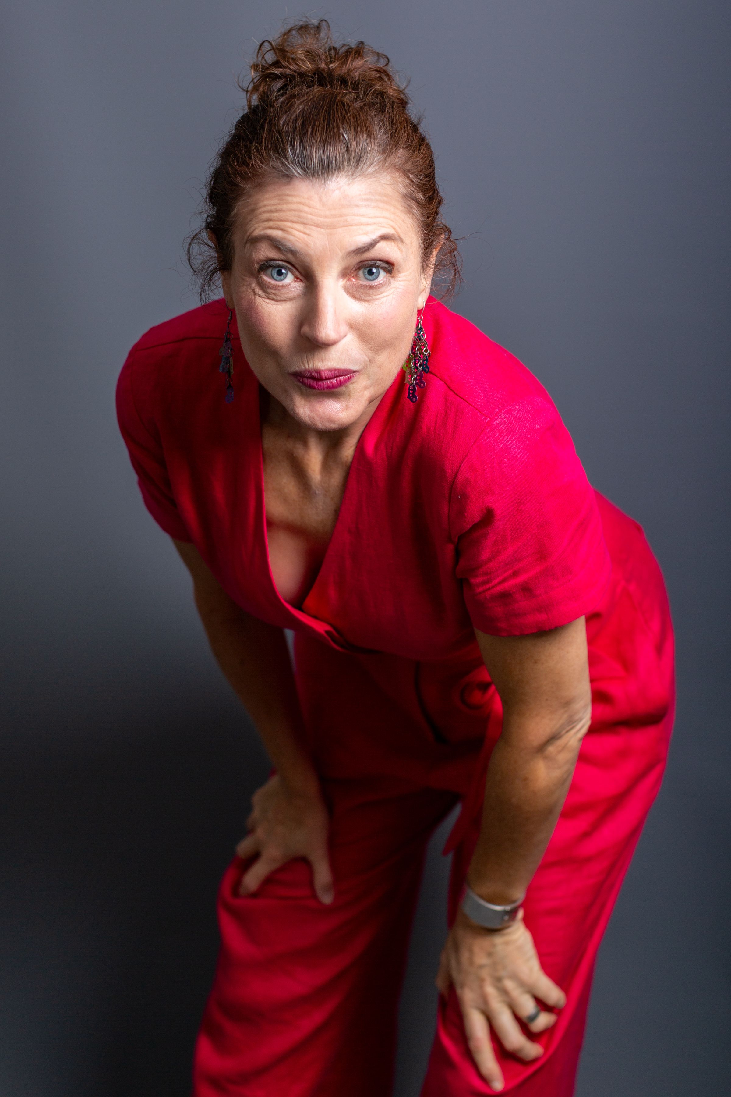 Person in a bright red dress poses expressively against a dark gray background in a series of dynamic shots.