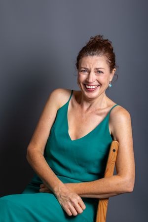 A series of professional studio portraits showing someone in a teal sleeveless top posing against a dark background.