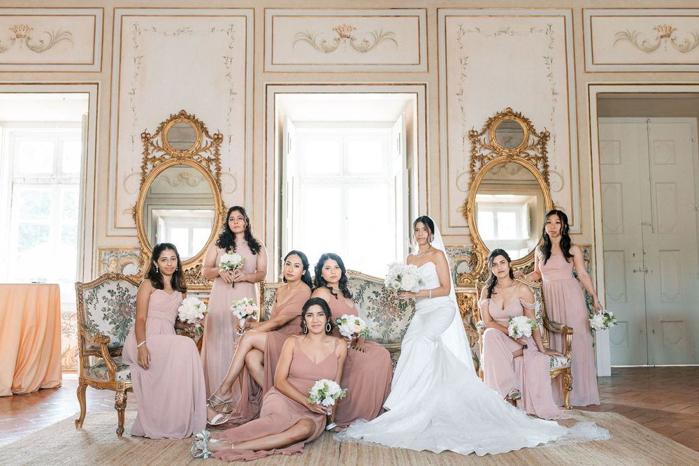 Bride with bridesmaids seated in palace room with ornate mirror and tiles, Palácio de Fronteira Lisbon