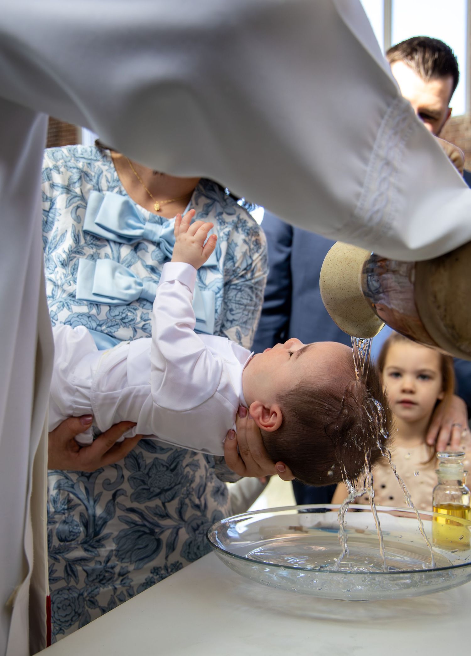 Sequence showing baptism ceremony with water being poured over in traditional ritual.