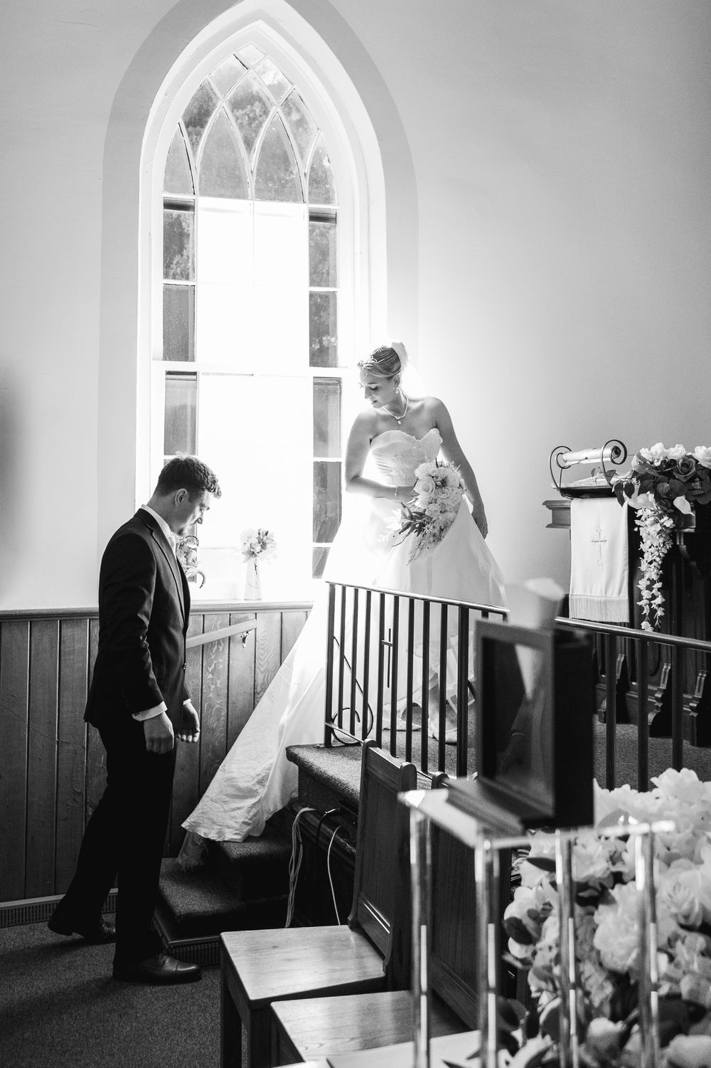 Black and white photos showing a church interior with arched windows and wooden wainscoting.