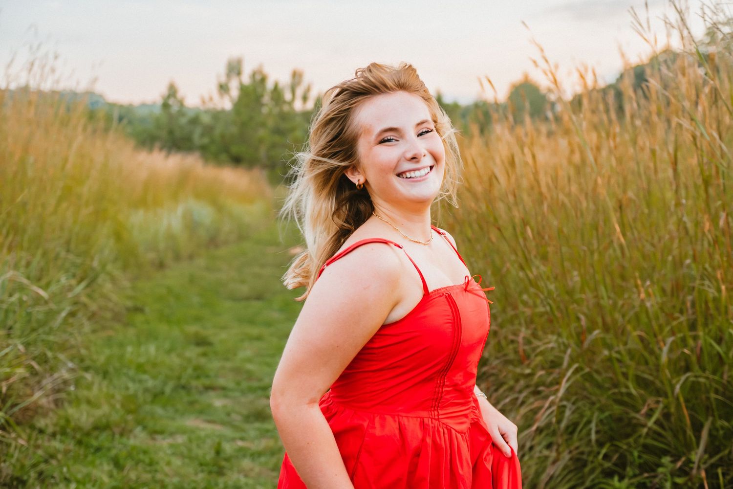 High School senior girl running through a field.