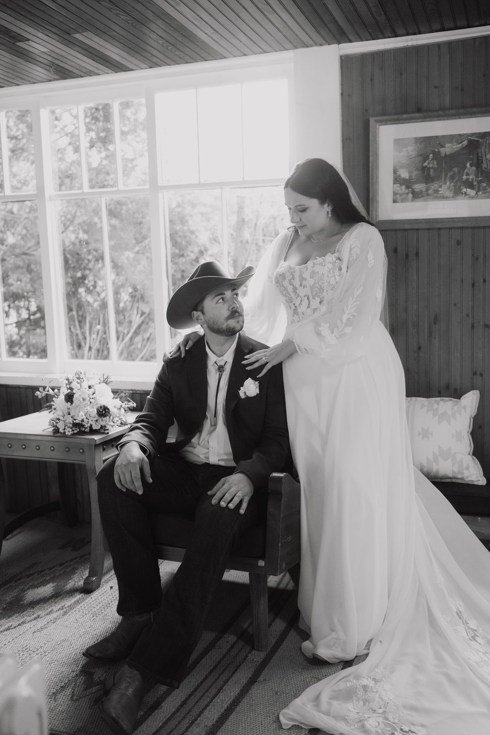 Black and white wedding photos showing couple sitting together on wooden bench in intimate conversation.