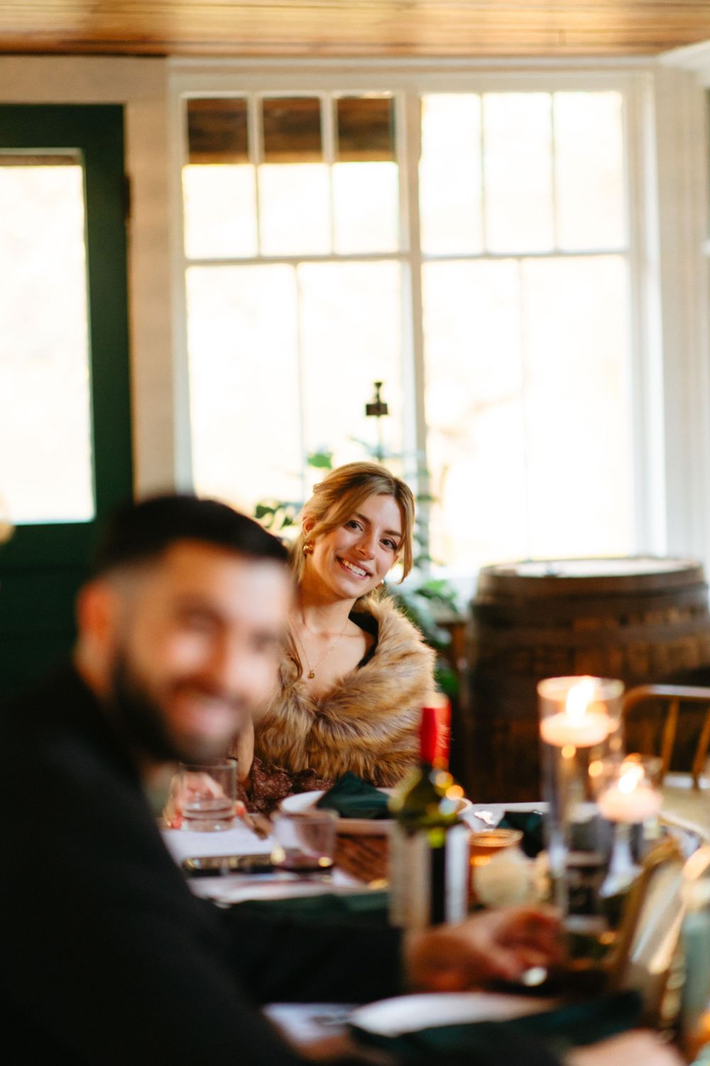 Wedding reception dining scene with soft focus and natural window lighting.