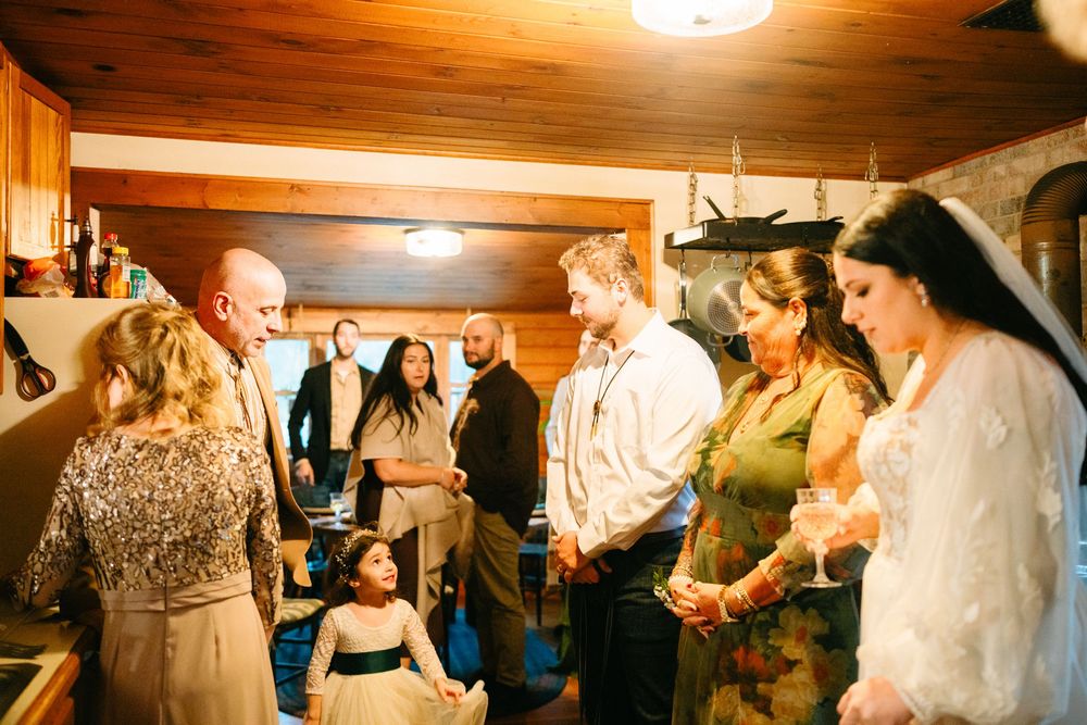 Wedding guests gather in a cozy wood-paneled room for an intimate celebration.