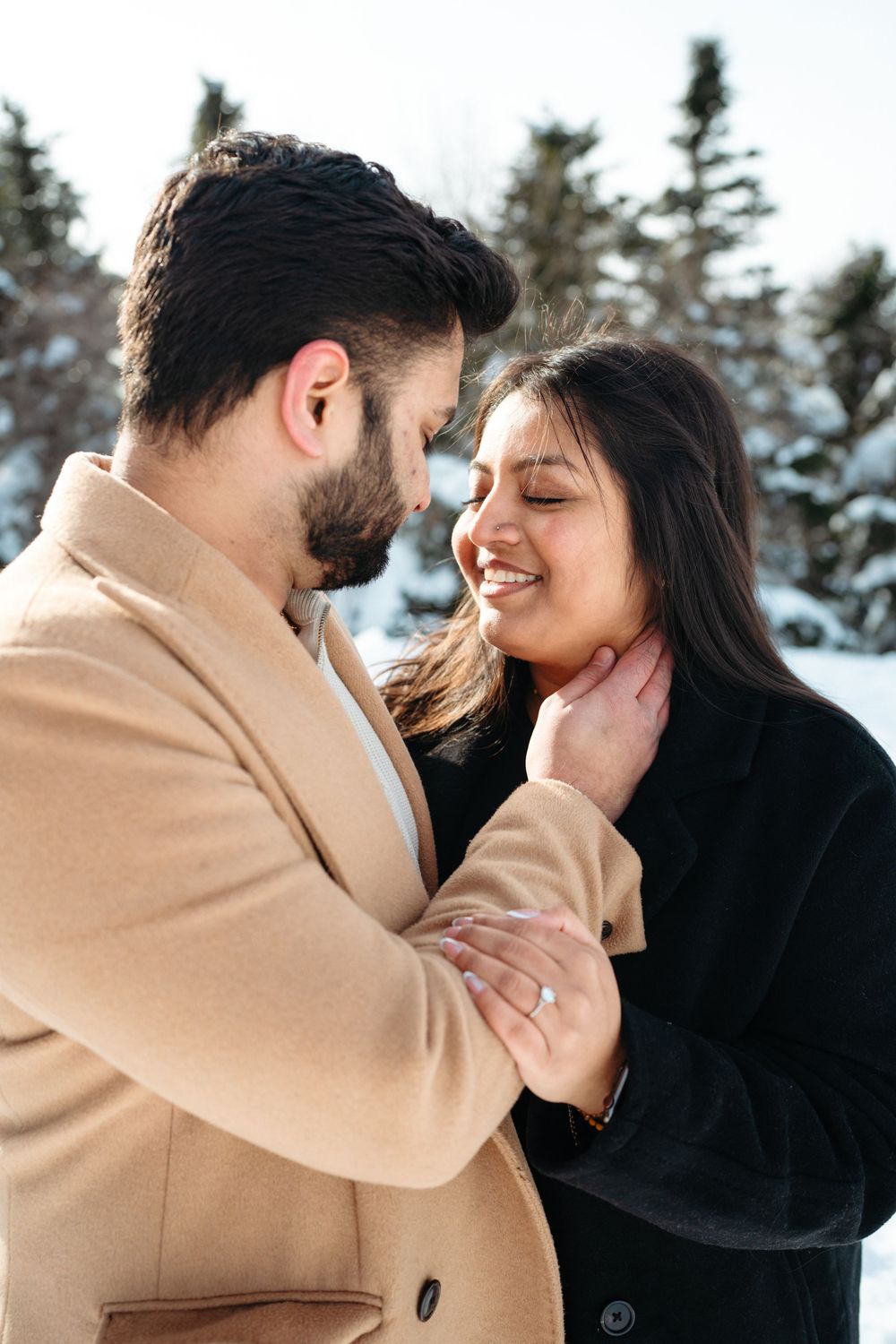 A romantic winter moment captured in a series of intimate poses against a snowy mountain backdrop.
