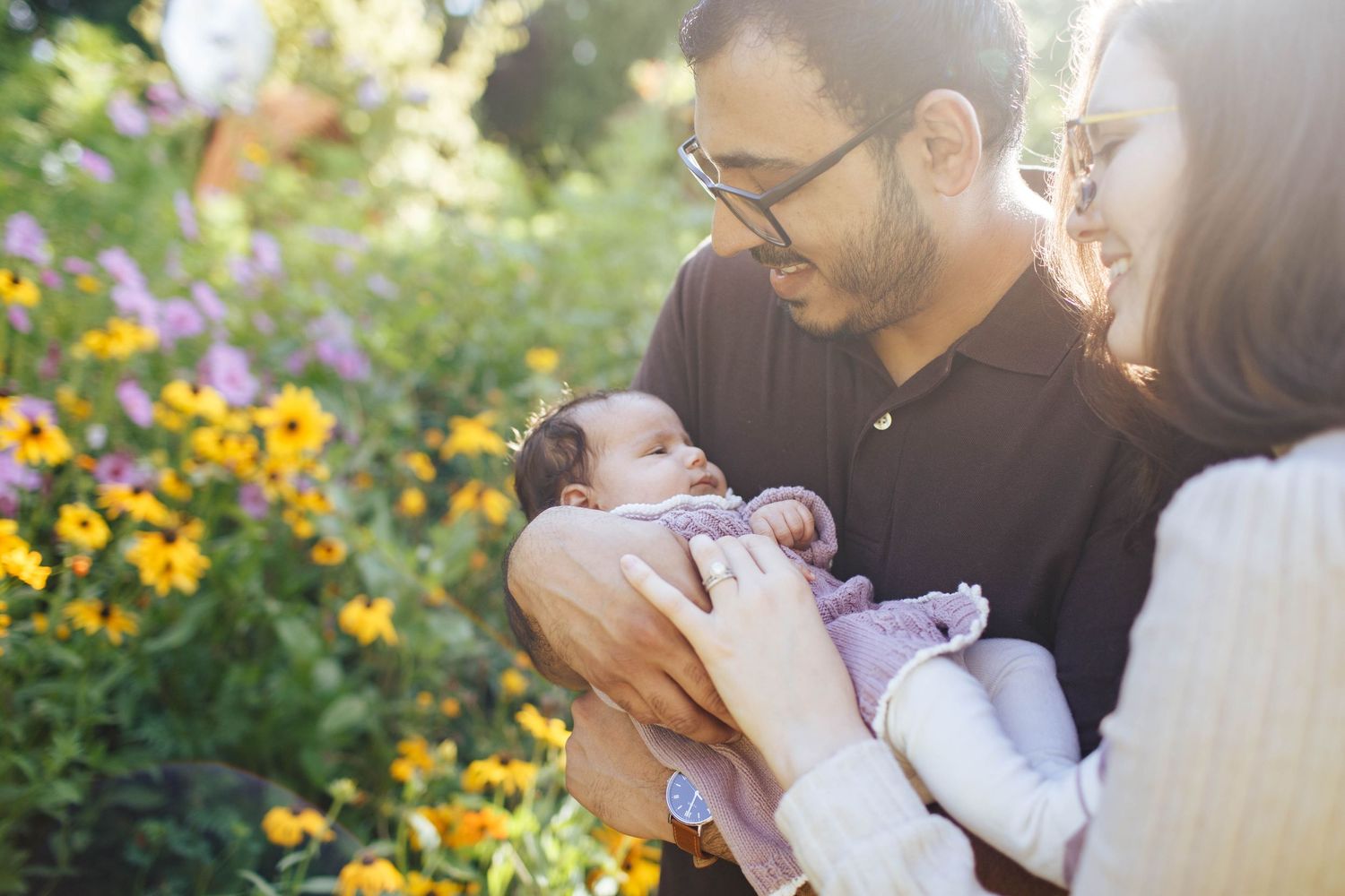baby photography in the Seattle area: A newborn baby with her parents at the Everett WA Arboretum during an outdoor photo session.