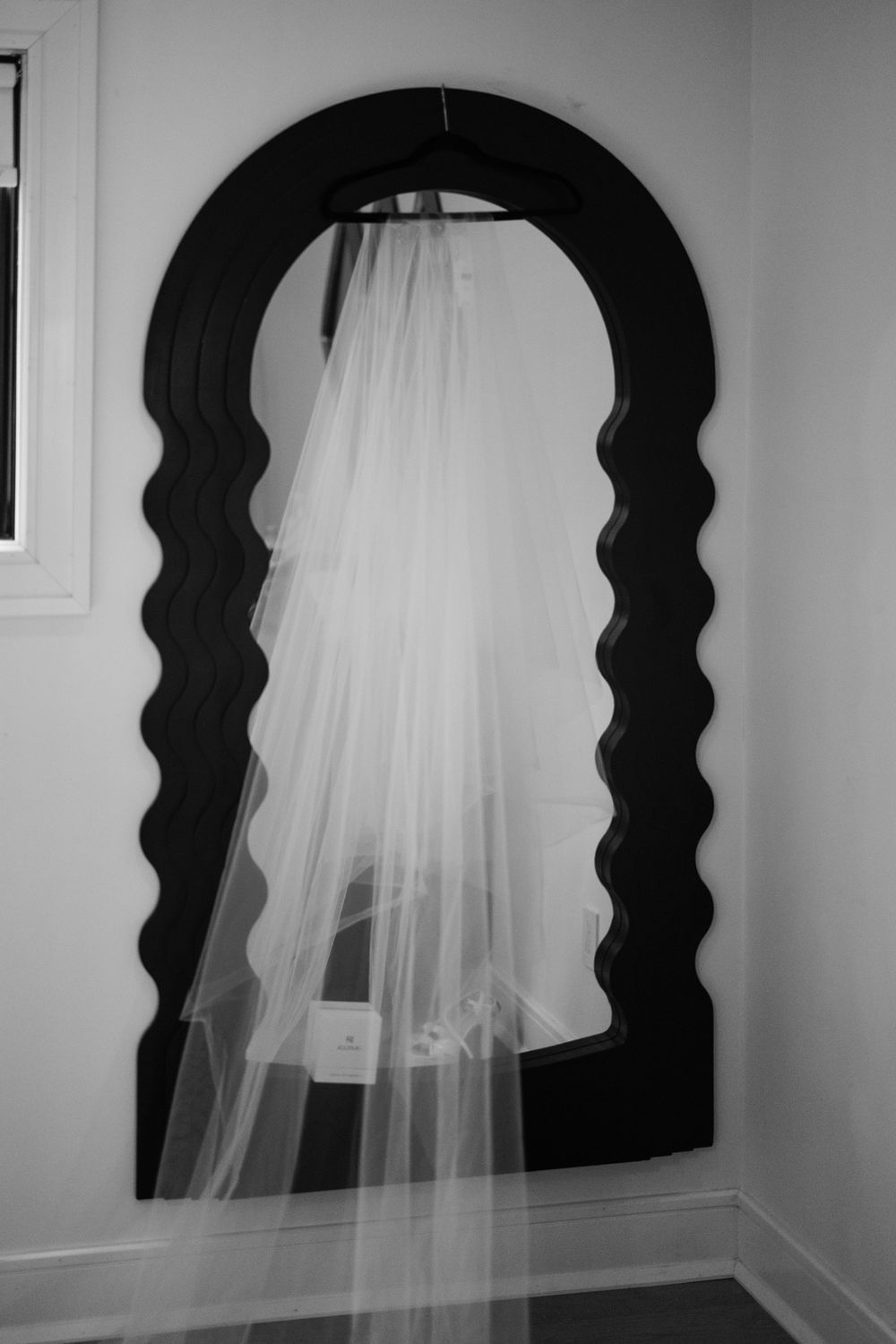 A black and white art installation shows silhouettes of human profiles in arched doorways with flowing white fabric.