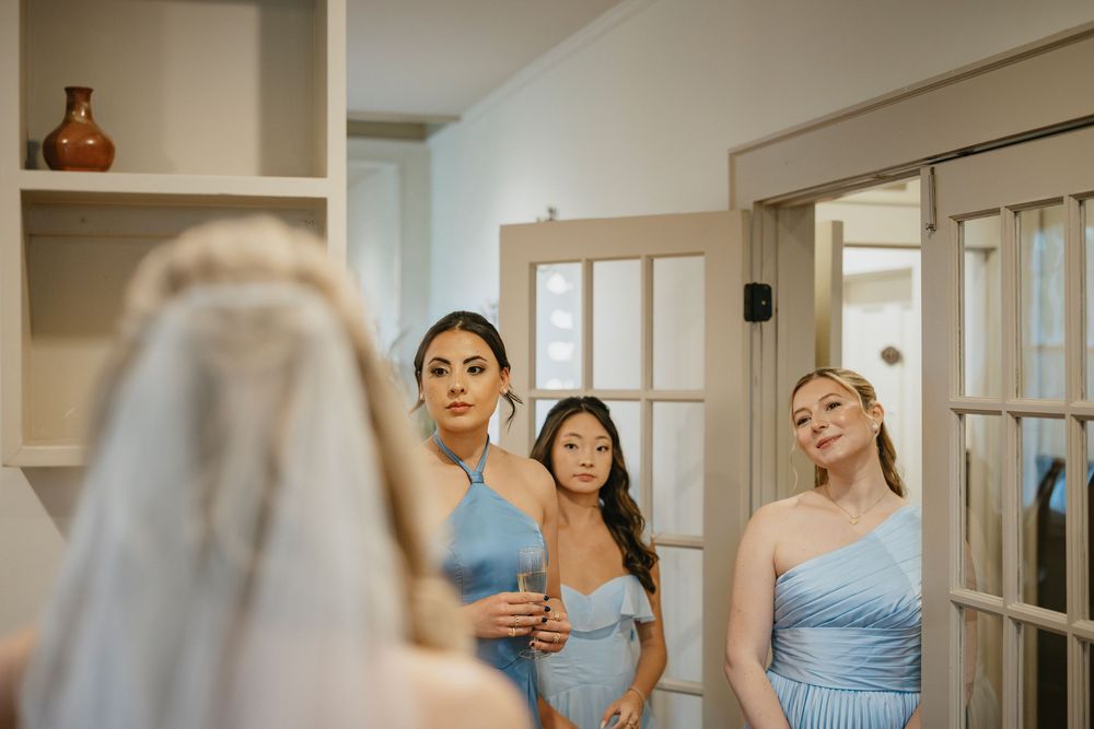 A series of candid moments captured during wedding preparations in a bridal suite with blue bridesmaid dresses.