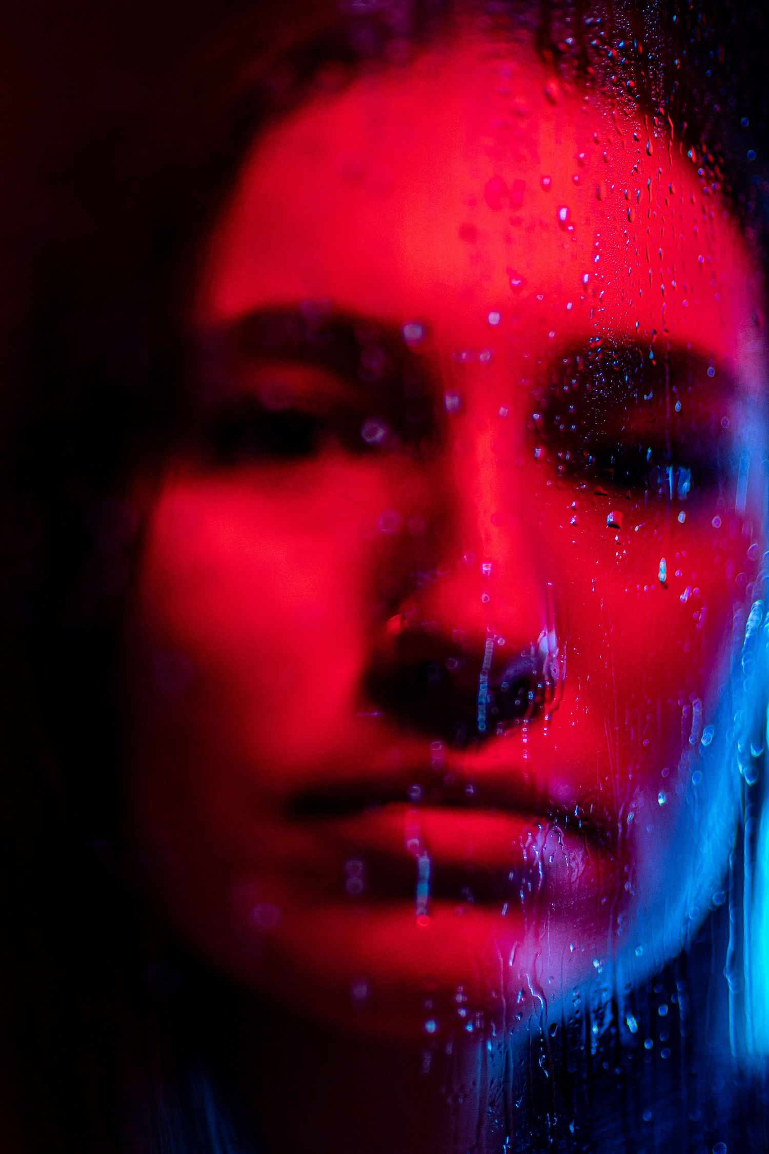 A series of portraits lit with dramatic blue and green lighting creating a moody artistic effect.