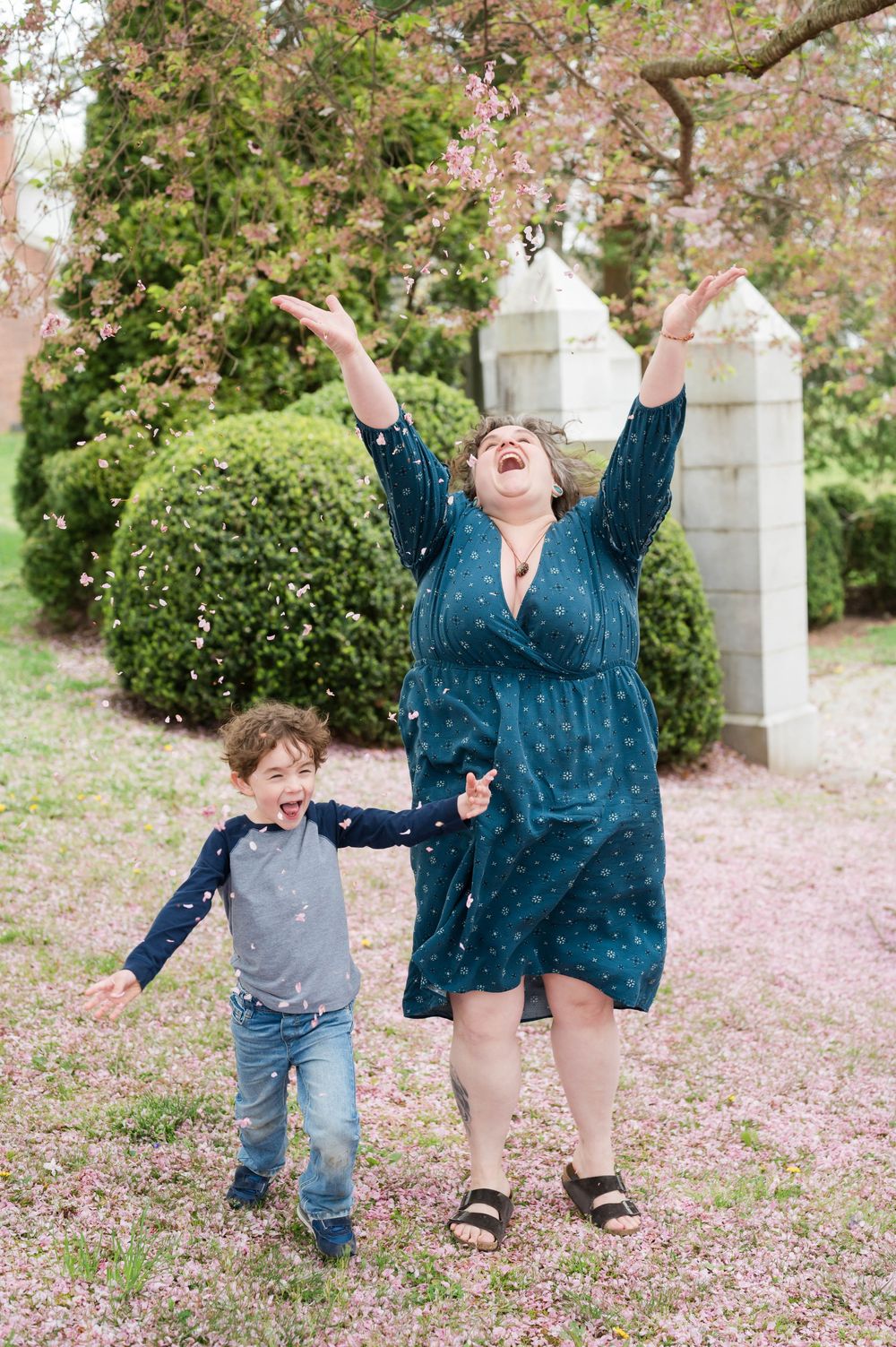 Energetic playtime moments captured under blooming cherry trees in a garden setting. Cherry Blossom Mini Sessions Branford CT