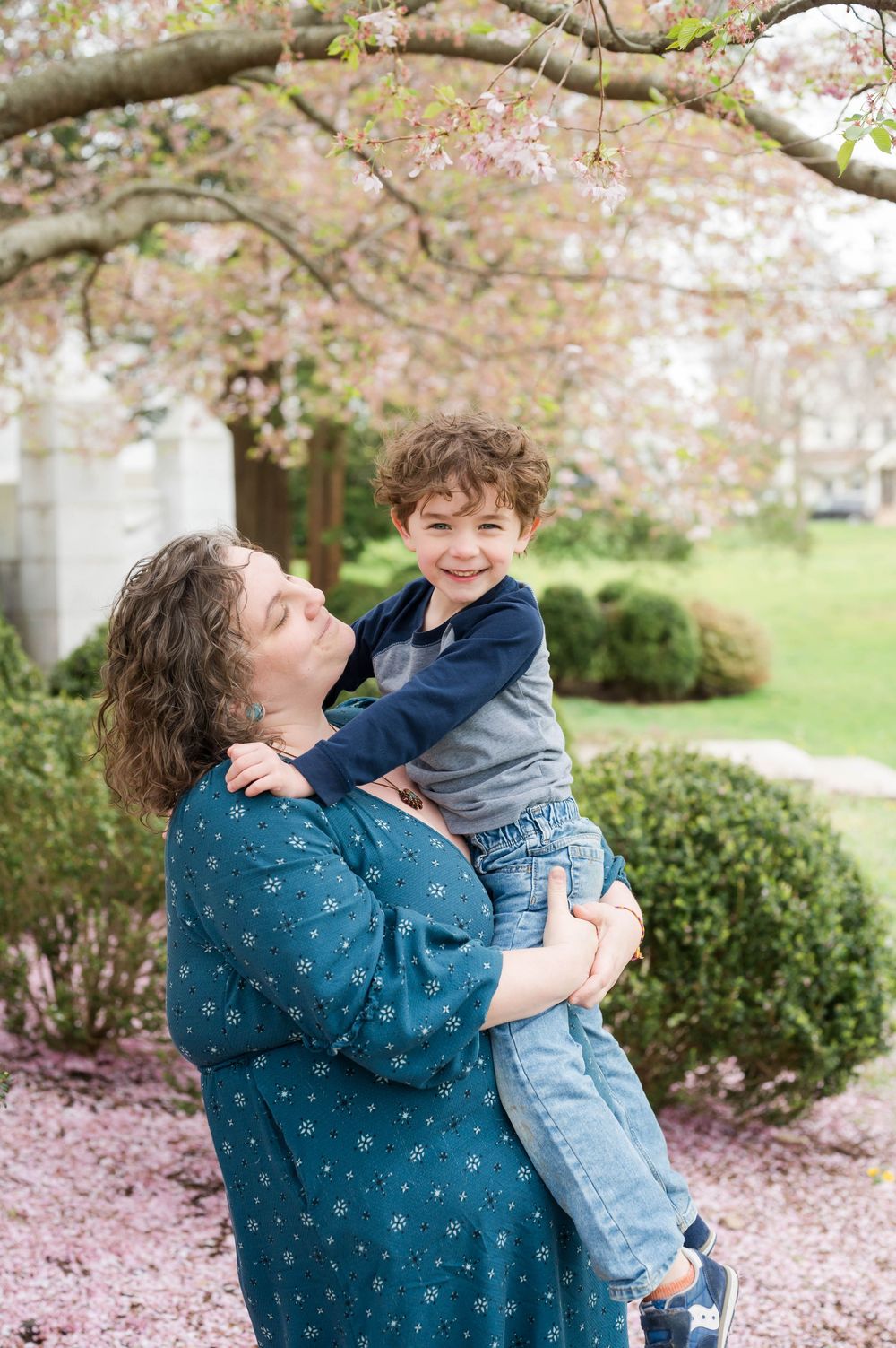 Playful interactions under cherry blossom trees with white columns in background. Cherry Blossom Mini Sessions Branford CT