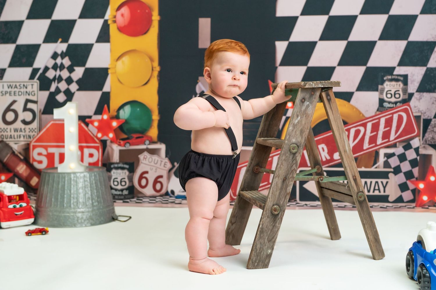 A vintage Route 66 themed room with checkered walls, racing flags, and retro decor creates a nostalgic automotive atmosphere.