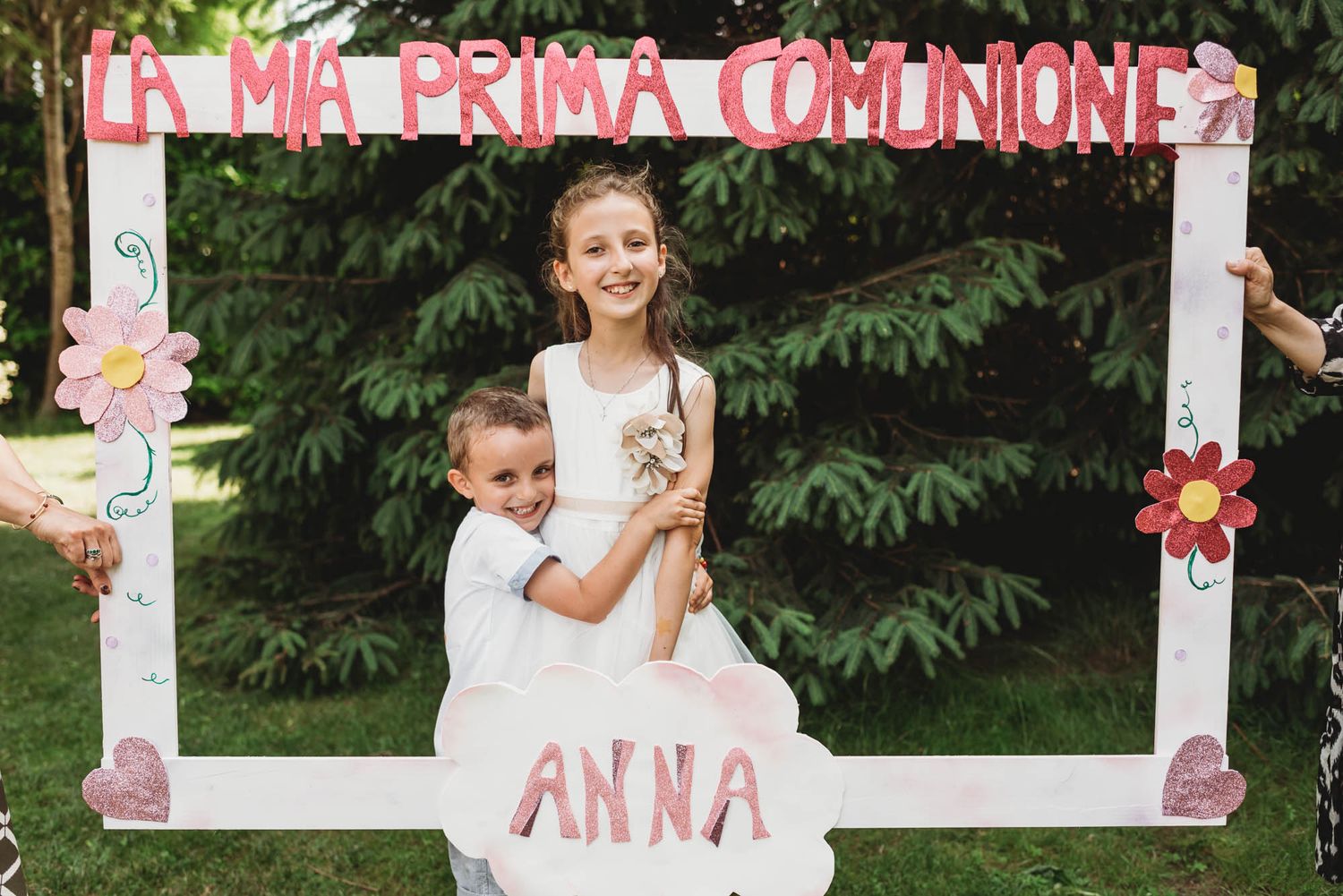 A decorated photo frame with pink text 'La Mia Prima Comunione' and floral accents for a special celebration.