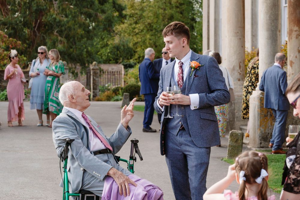 Elmore Court Wedding by Cotswolds Zara Davis Photography in Gloucestershire groom with his grandad in front of manor house