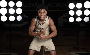 Cathedral Academy basketball player posing energetically in front of circular studio lights on an indoor court in Charleston South Carolina