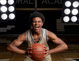 Cathedral Academy basketball player posing with a basketball during a portrait session in a gymnasium in Charleston South Carolina