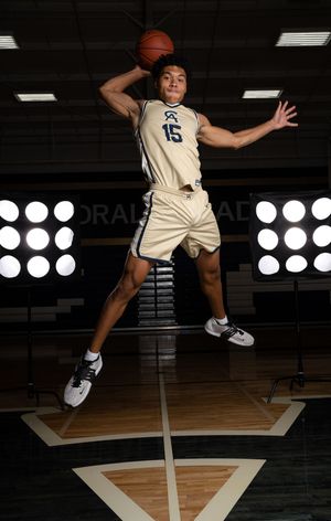Cathedral Academy basketball player in a white uniform performing a jumping motion sequence on a wooden court in Charleston South Carolina