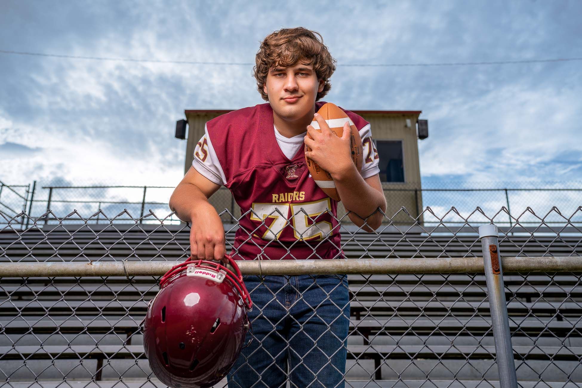 Dorchester Academy athlete in maroon jersey and blue shorts holding a bowling ball during bowling motion