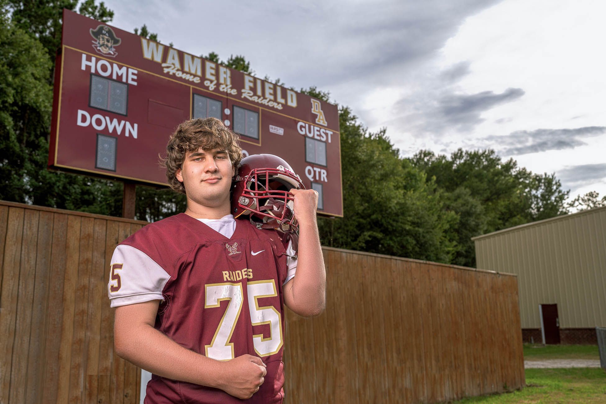 Dorchester Academy high school football players in maroon uniforms posing together on a football field in St George South Carolina