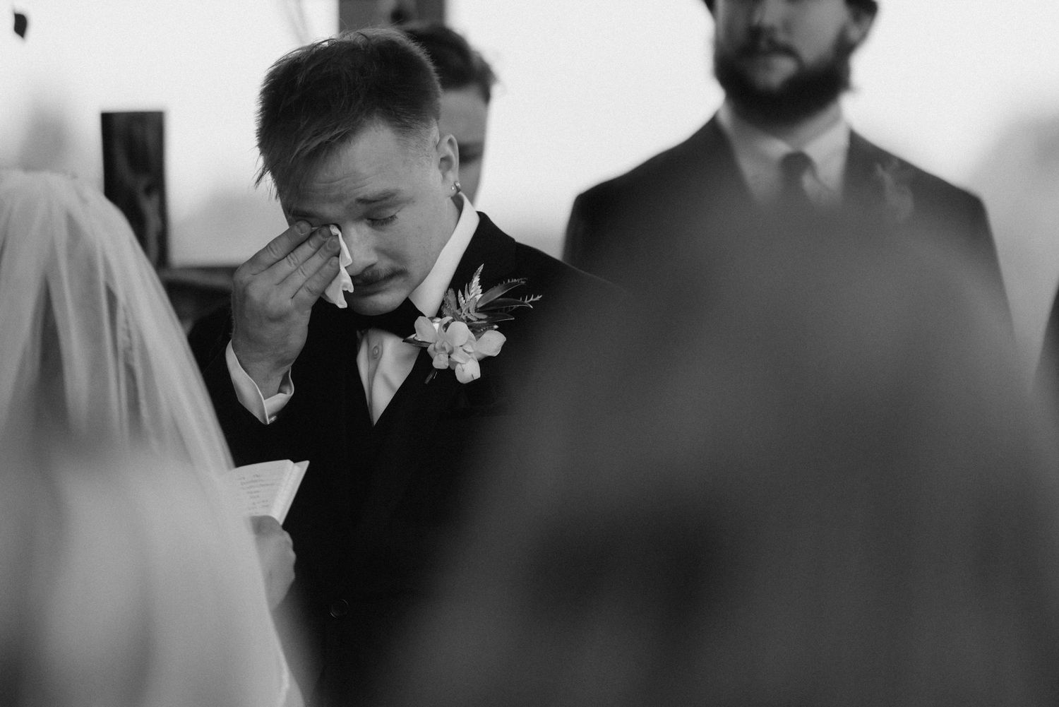 A joyous celebration at an elegant wedding reception with guests laughing and dancing together.